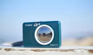 Niebieski aparat Canon Zoemini S2, idealny aparat na wakacje, gotowy do łapania wspomnień.