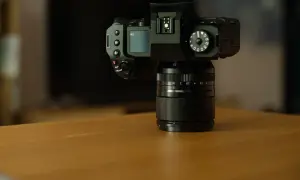 Czarny aparat Fujifilm xh2 z obiektywem na drewnianym stole.