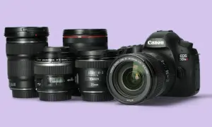 Kilka obiektywów Canon i korpus aparatu EOS 5Ds R na jasnofioletowym tle.