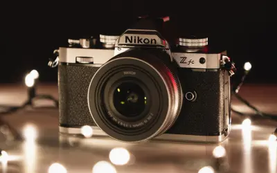 Nikon Z fc, jeden z rodzajów aparatów, otoczony świątecznymi lampkami.