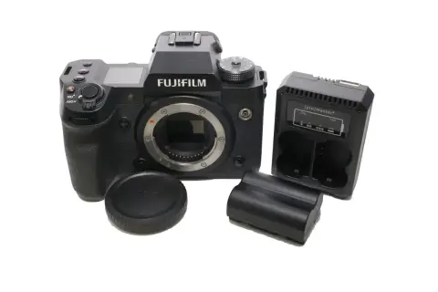 Aparat Fujifilm xh2s z obiektywem, ładowarką i bateriami.