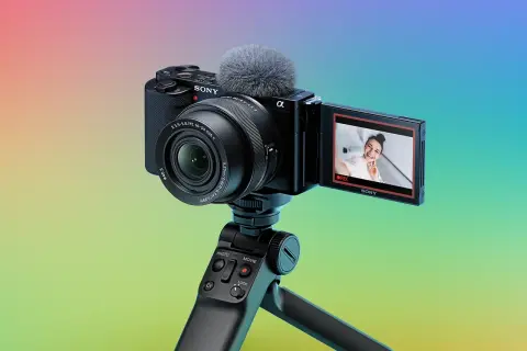 Kamera Sony zve10 z mikrofonem na statywie, gotowa do nagrywania uśmiechniętej vlogerki.