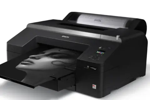 Czarna drukarka Epson z wydrukiem portretu kobiety. To najlepsza drukarka do zdjęć, która ożywia Twoje wspomnienia.