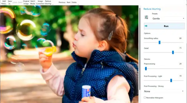 Dziewczynka dmucha bańki. Program Easy Photo Unblur pomaga jak wyostrzyć zdjęcie, oferując opcje redukcji rozmycia i poprawy detali.