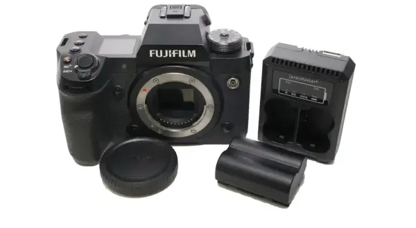 Aparat Fujifilm xh2s z obiektywem, ładowarką i bateriami.