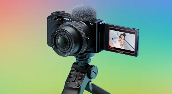 Kamera Sony zve10 z mikrofonem na statywie, gotowa do nagrywania uśmiechniętej vlogerki.