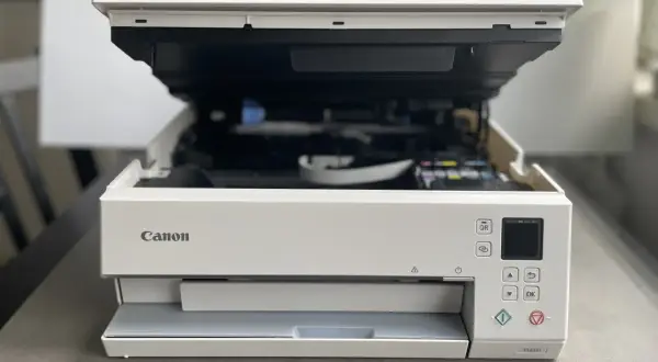 Drukarka Canon TS6351 z otwartą klapą, gotowa do drukowania. Dowiedz się, jak połączyć drukarkę Canon z telefonem, by drukować bezprzewodowo.