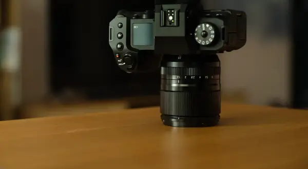 Czarny aparat Fujifilm xh2 z obiektywem na drewnianym stole.