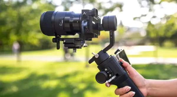Profesjonalny gimbal stabilizuje aparat z obiektywem, zapewniając płynne ujęcia. To właśnie gimbal co to za urządzenie, które ułatwia filmowanie.