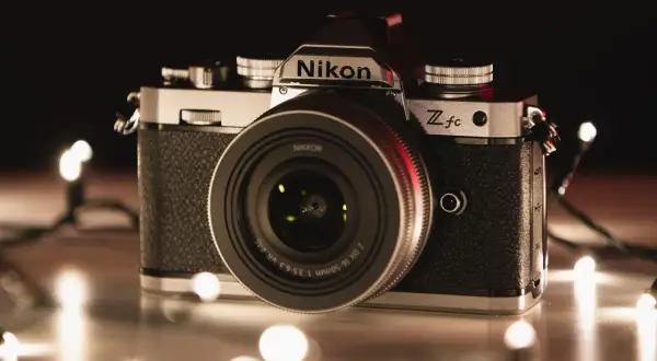 Nikon Z fc, jeden z rodzajów aparatów, otoczony świątecznymi lampkami.