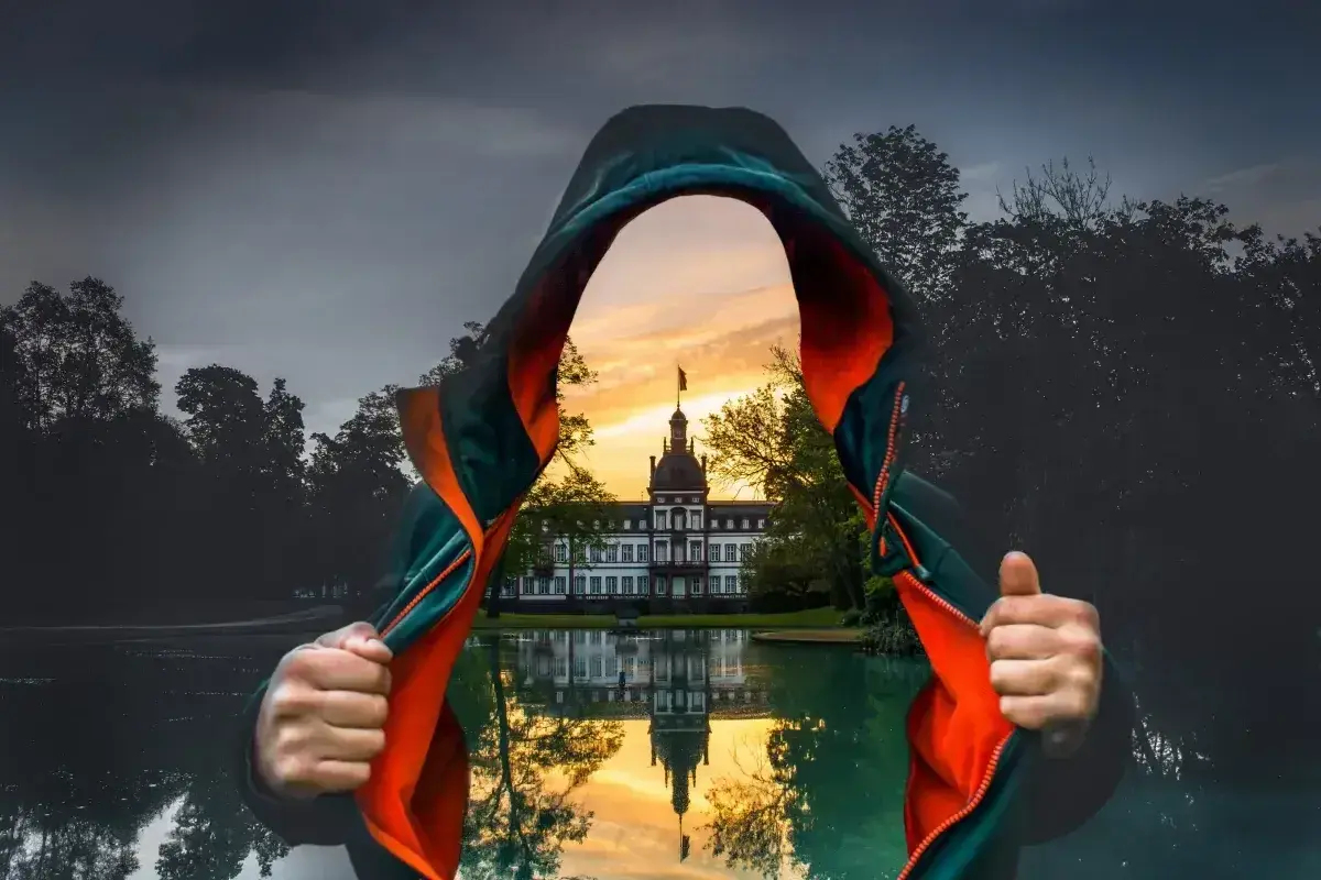 Osoba w kapturze odsłania widok na pałac odbijający się w wodzie. Efektowne łączenie zdjęć w jedno.