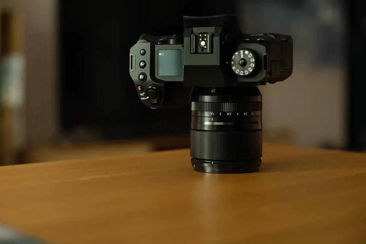 Czarny aparat Fujifilm xh2 z obiektywem na drewnianym stole.