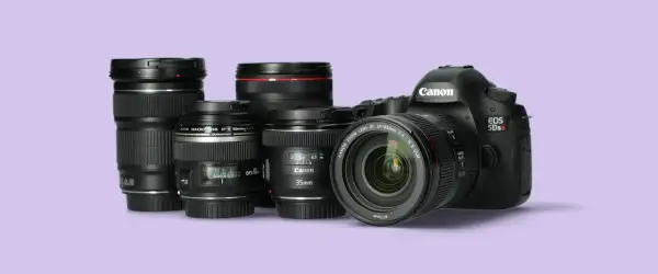 Kilka obiektywów Canon i korpus aparatu EOS 5Ds R na jasnofioletowym tle.