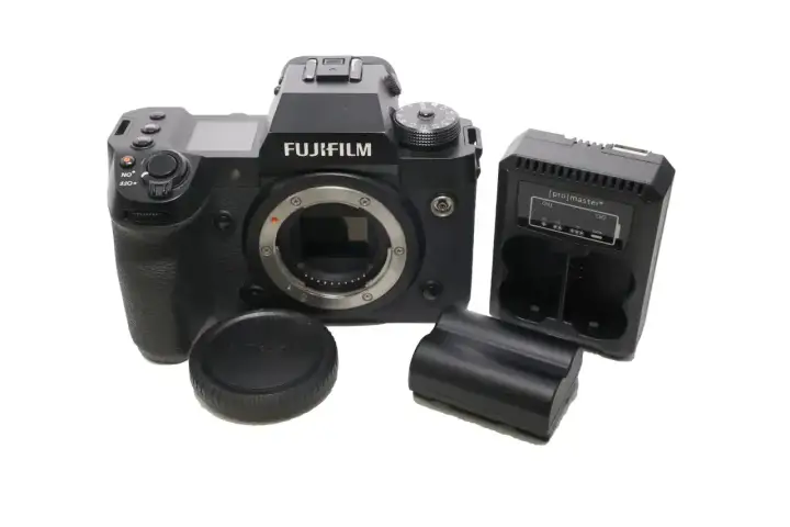 Aparat Fujifilm xh2s z obiektywem, ładowarką i bateriami.