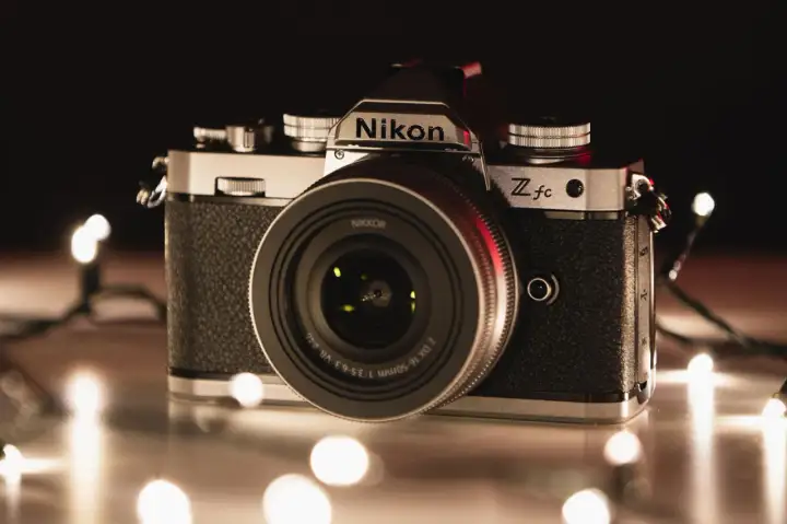 Nikon Z fc, jeden z rodzajów aparatów, otoczony świątecznymi lampkami.